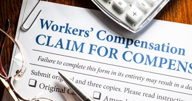 Workers' Compensation form with pen and glasses